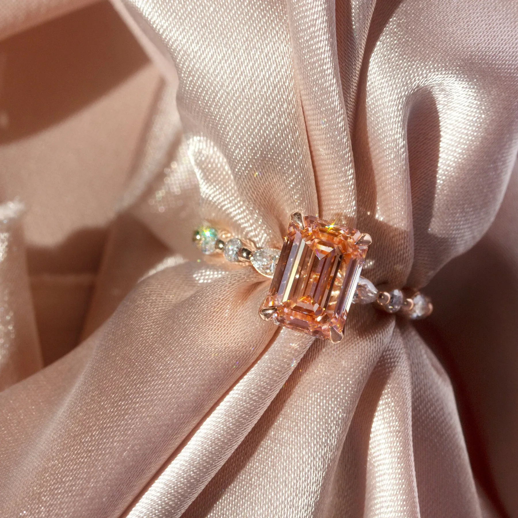 Anillo de diamante rosa sobre seda color champán